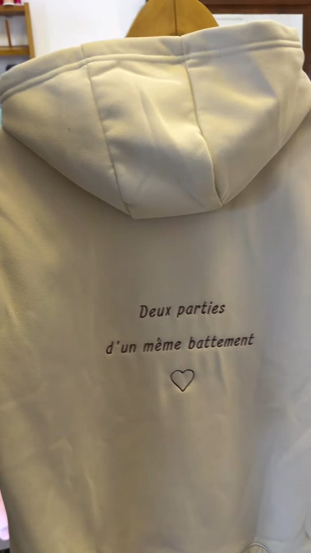 Dos de hoodie beige brodé « Deux parties d'un même battement »