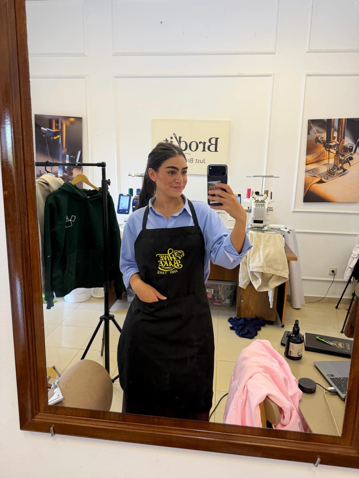 Membre de l'équipe Brod'it en tablier noir brodé dans l'atelier